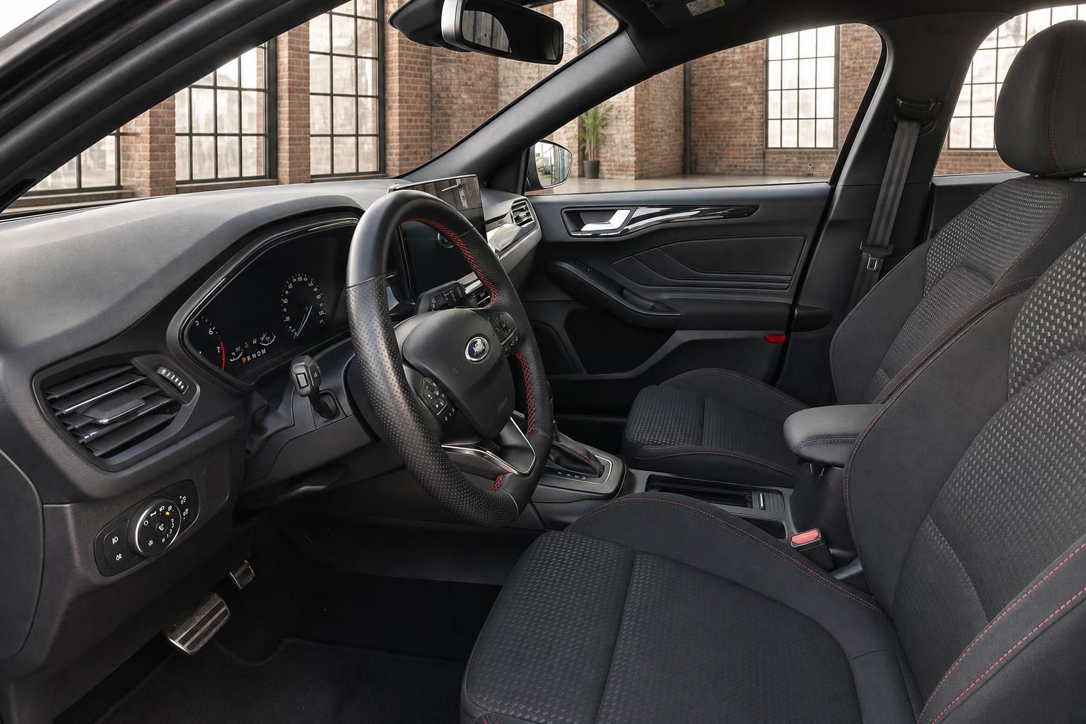 Ford Innenraum Fahrerseite mit Lenkrad, Cockpit, Automatikgetriebe und schwarzen Sportsitzen mit roter Ziernaht