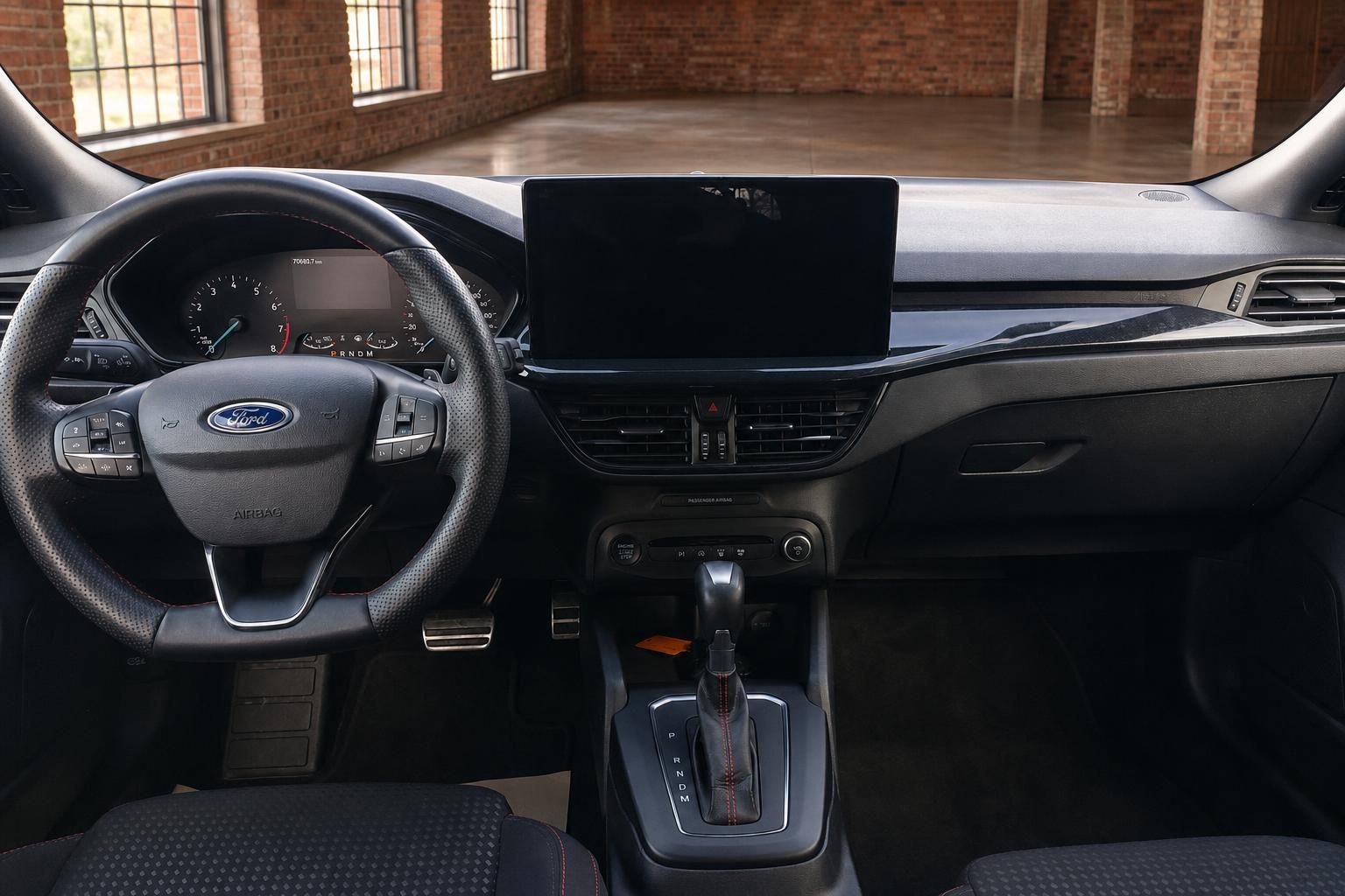Ford Focus Cockpit mit Lenkrad, digitalem Tacho, großem Touchscreen und Automatikschalthebel mit roter Ziernaht