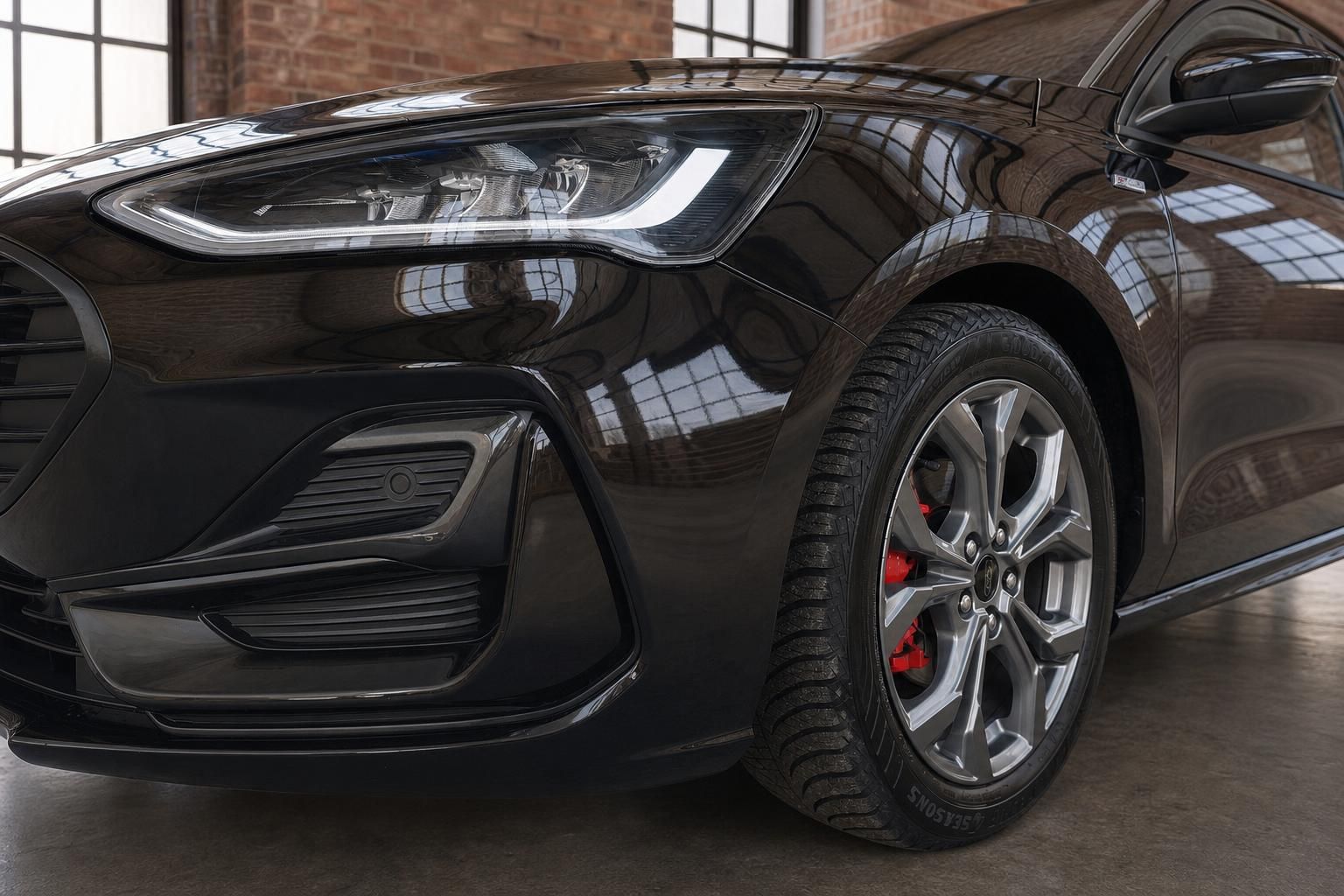 Ford Focus ST-Line schwarzer Scheinwerfer und Felge Detailaufnahme mit roten Bremssätteln