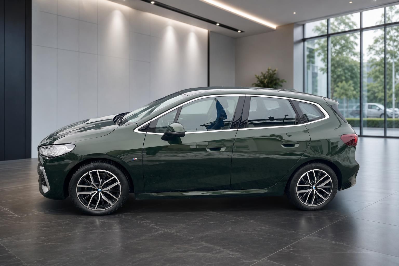 BMW 2er Active Tourer in Gruen, Seitenansicht im Showroom