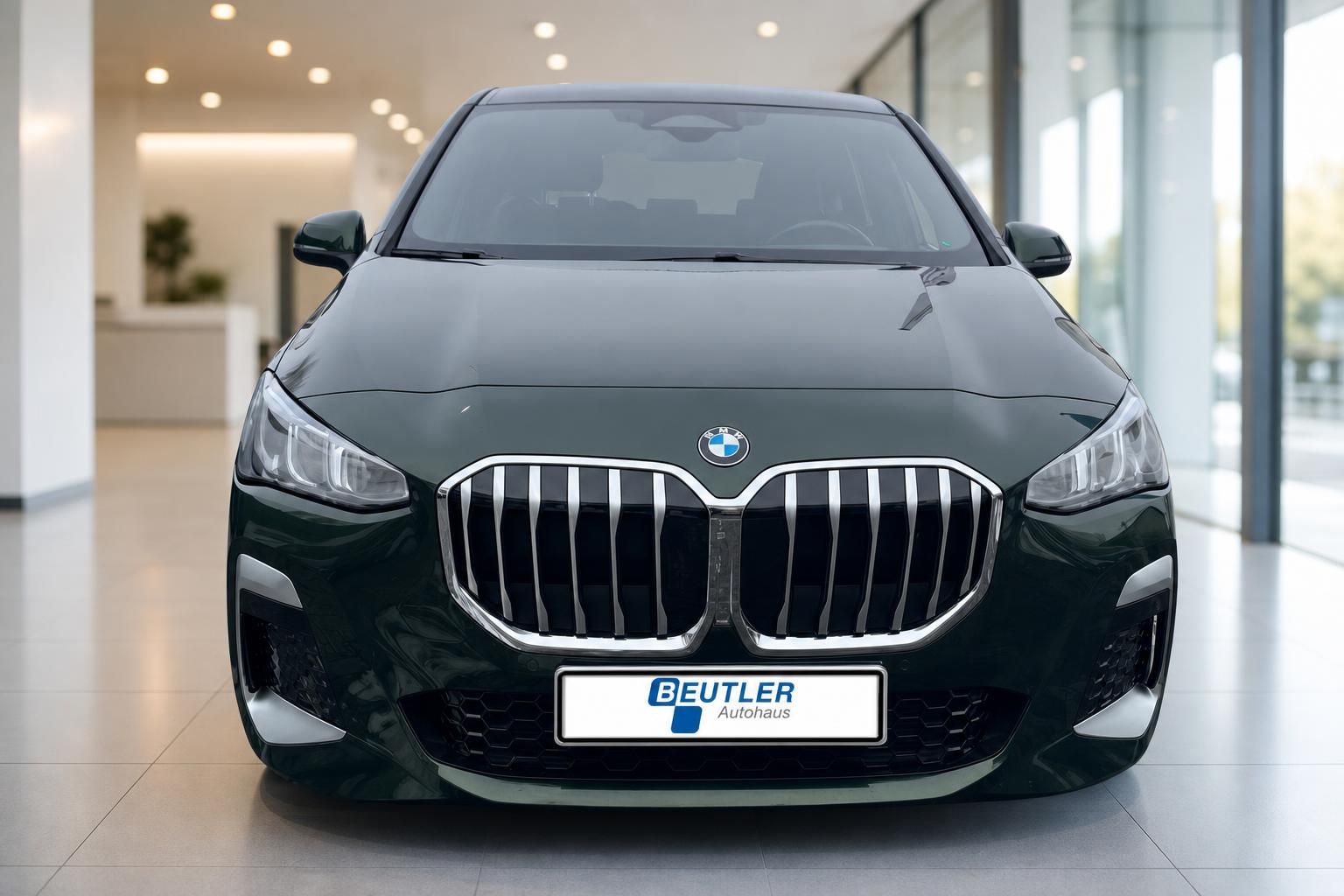 BMW 2er Active Tourer gruen Frontansicht mit Niere im Showroom