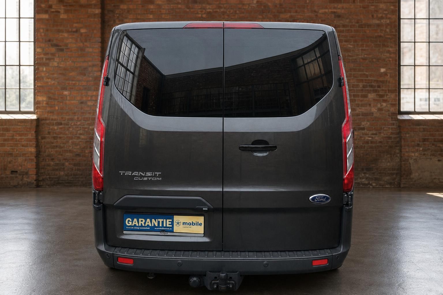 Ford Transit Custom grau, Heckansicht in Loft-Halle