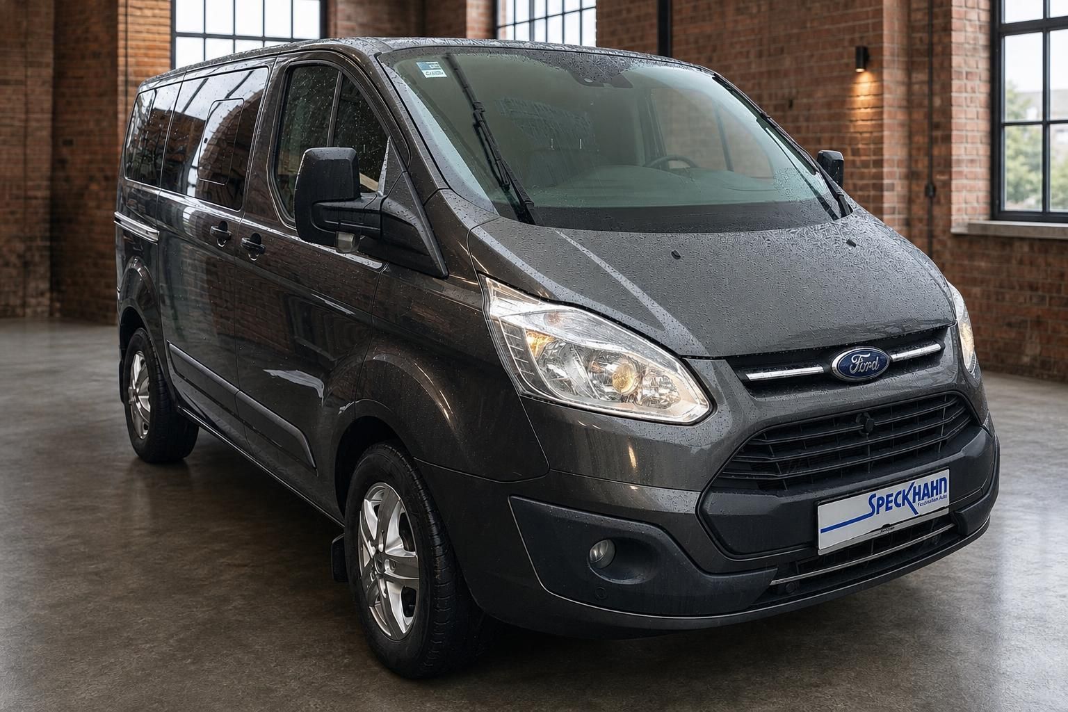 Ford Transit Custom grau, Frontansicht schräg im Showroom