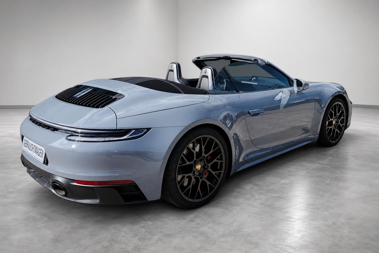 Porsche 911 Cabrio hellblau, Heck-Seitenansicht mit offenem Verdeck und Sportfelgen