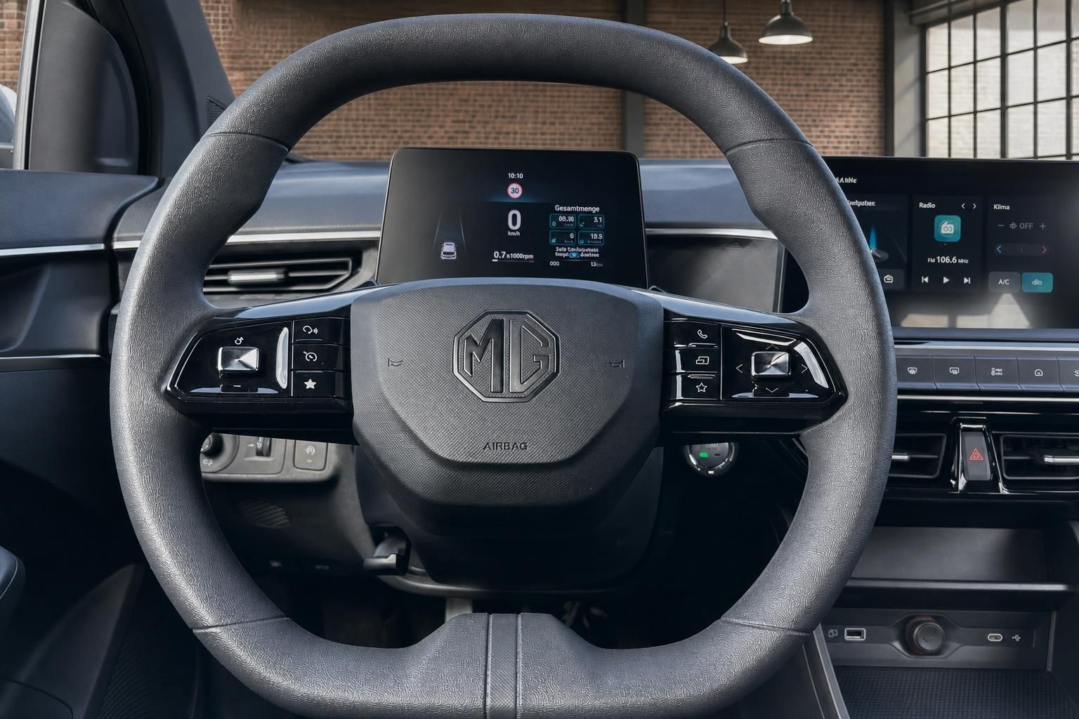 Nahaufnahme MG Lenkrad mit Logo, Bedienelementen und Infotainment-Display