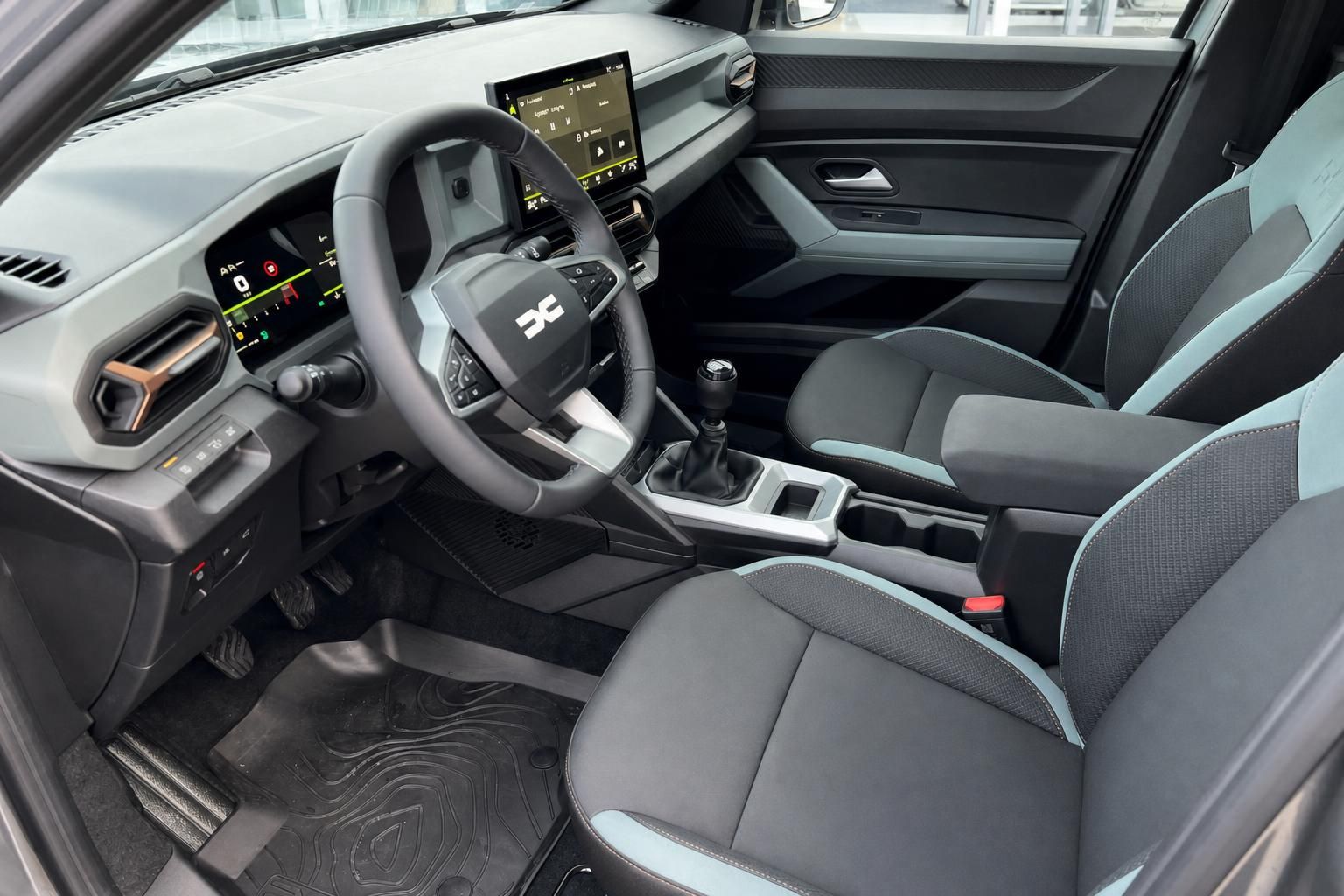 Dacia Bigster Innenraum mit Lenkrad, Touchscreen und Sportsitzen in Grau-Türkis