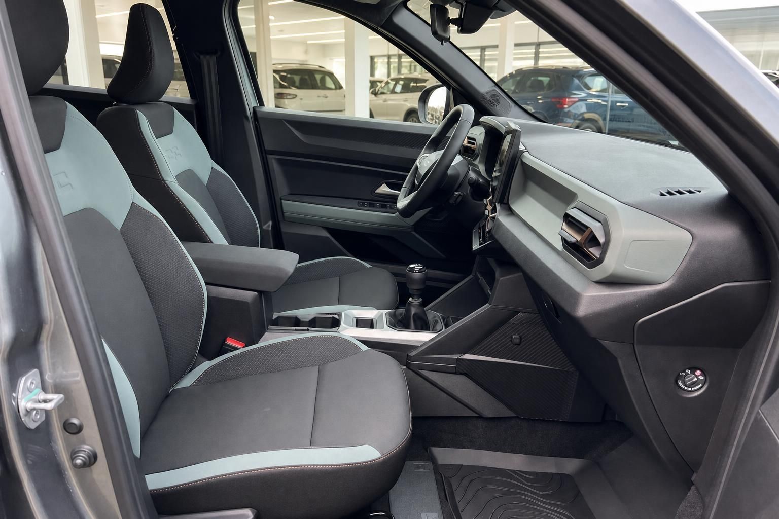 Fahrzeug Cockpit mit grauen Sitzen, Lenkrad und modernem Infotainment-System