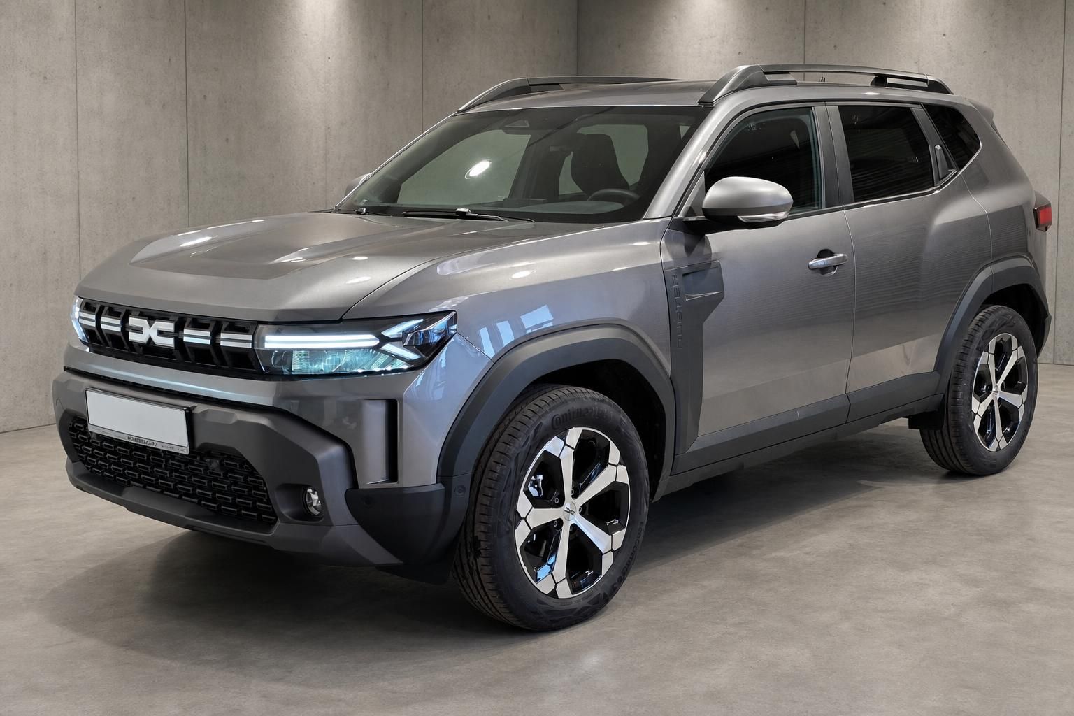 Dacia Duster grau, Frontansicht schräg, SUV in Betonhalle fotografiert