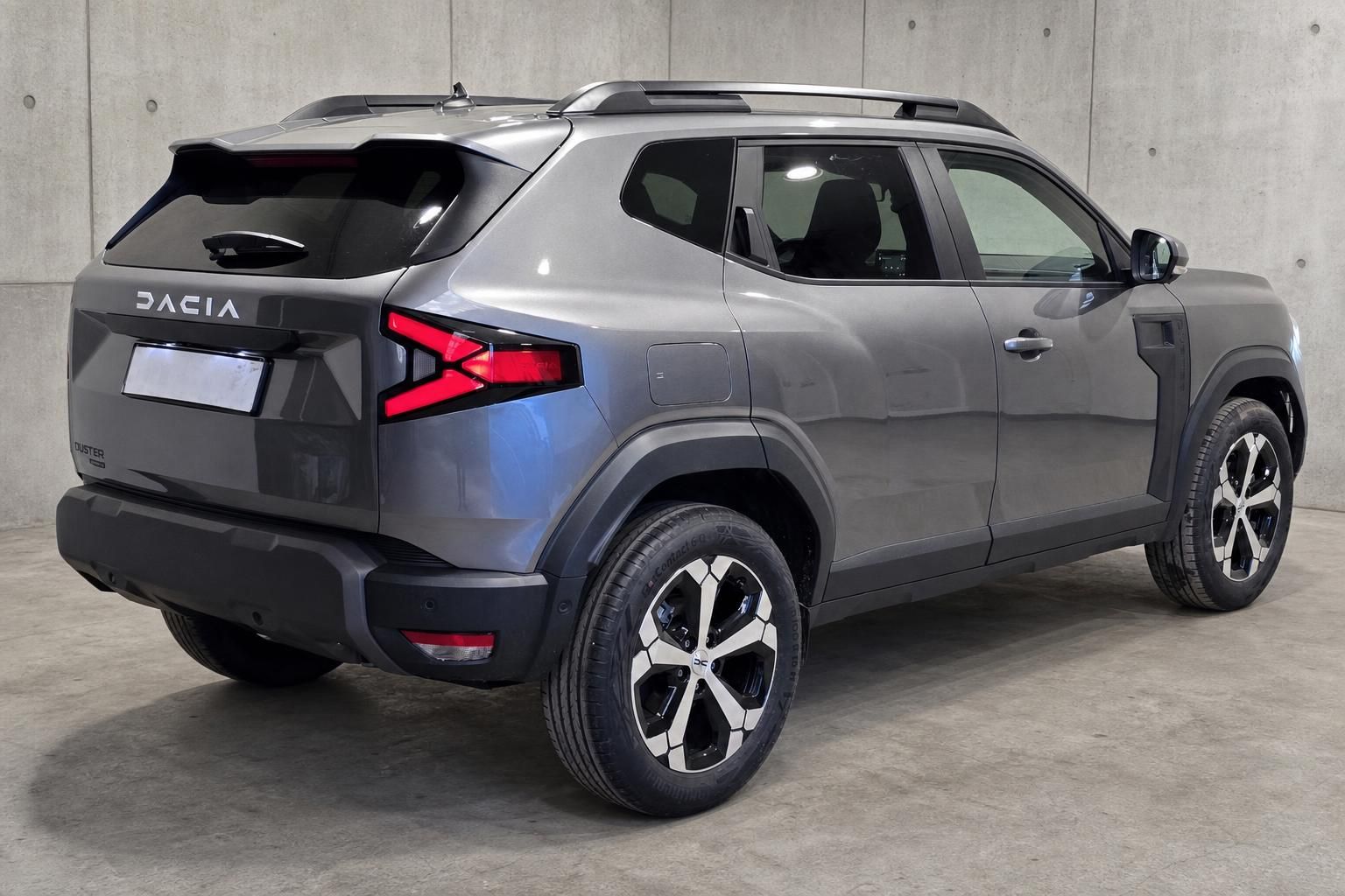Dacia Duster grau, Heckansicht schräg mit Alufelgen und LED-Rückleuchten
