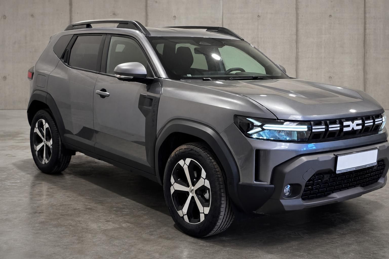 Dacia Duster grau, seitliche Frontansicht mit markantem Kühlergrill