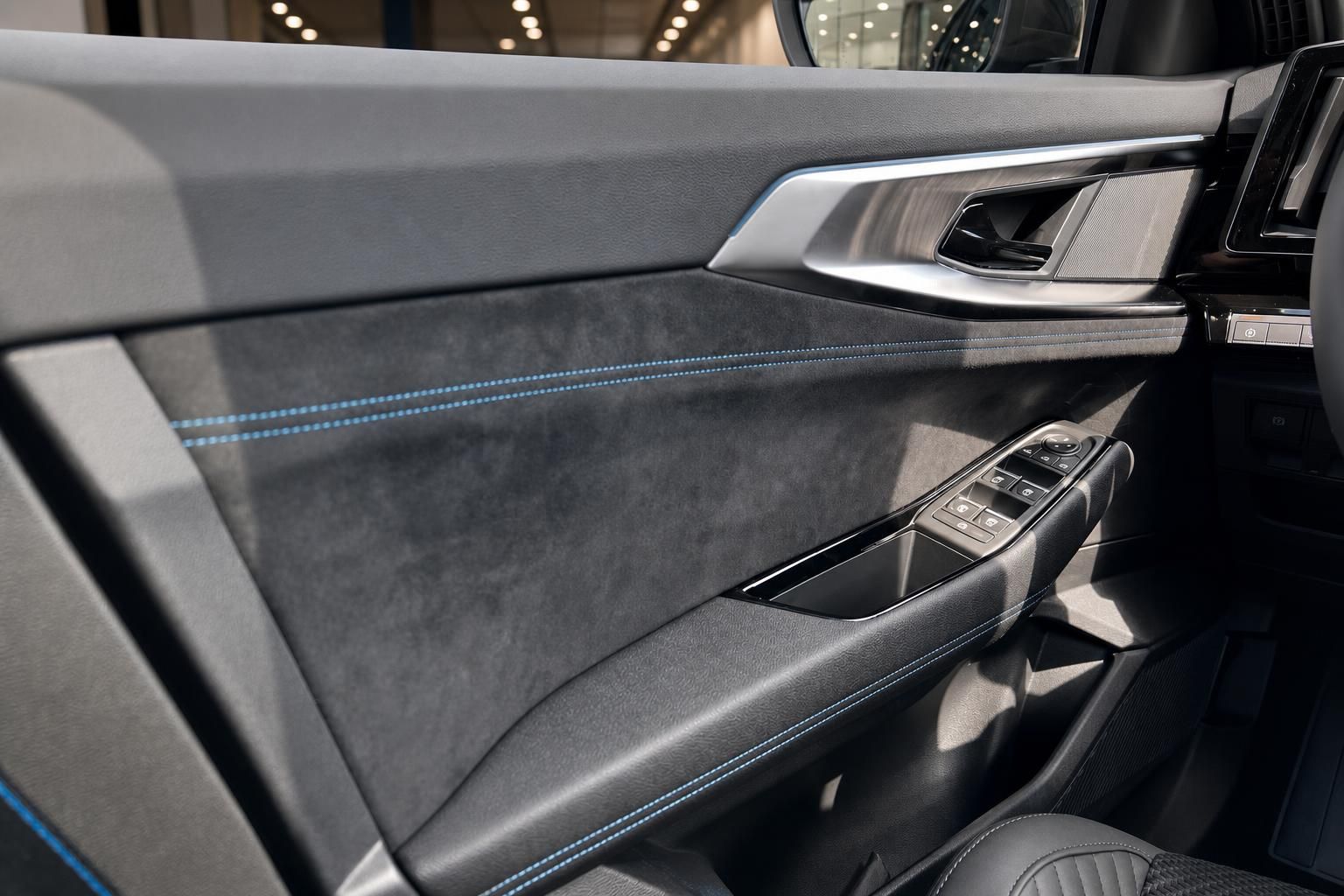 Türverkleidung mit Alcantara und blauer Ziernaht sowie Bedienelementen