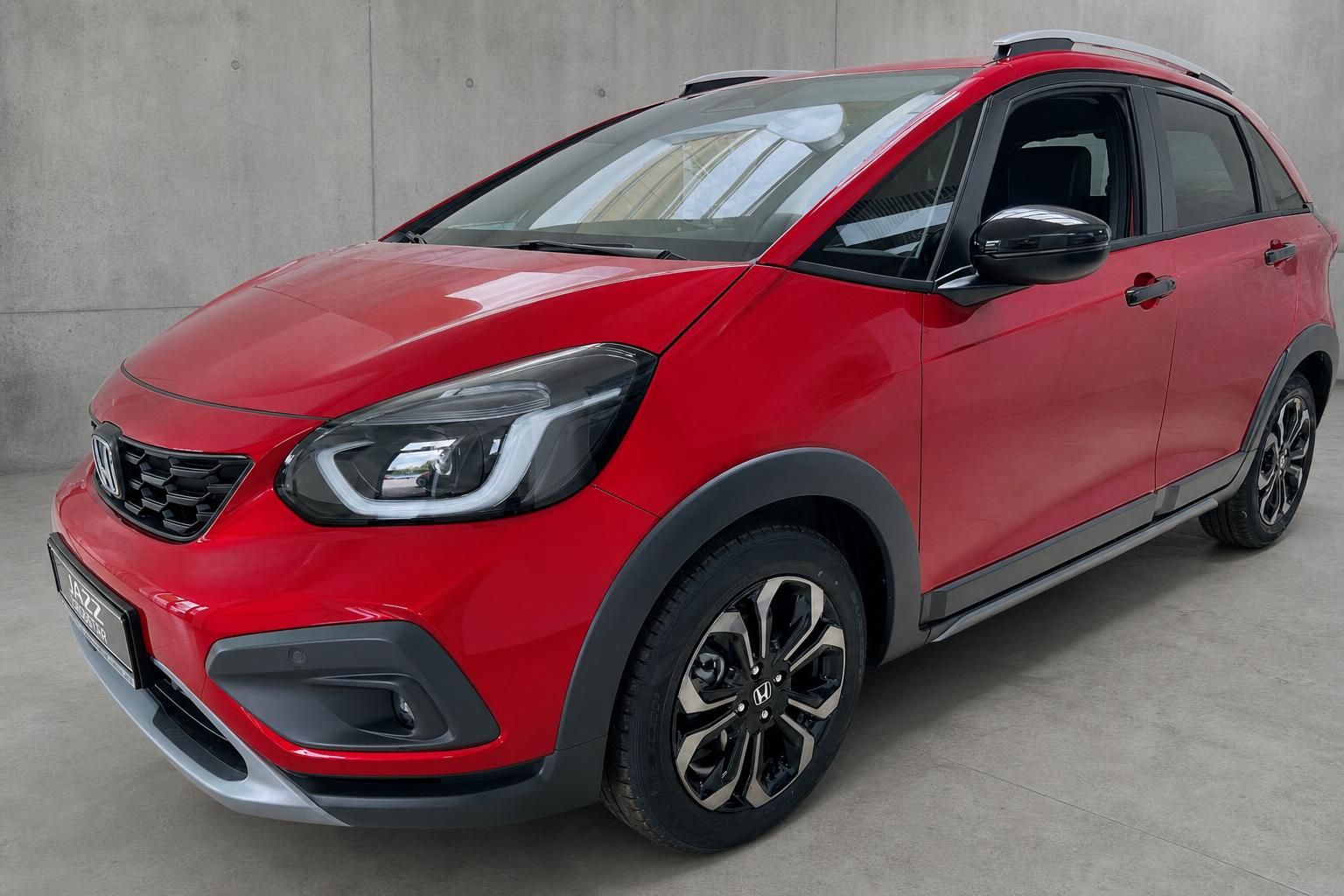 Honda Jazz Crosstar rot, Seitenansicht vorne mit Dachreling und Alufelgen