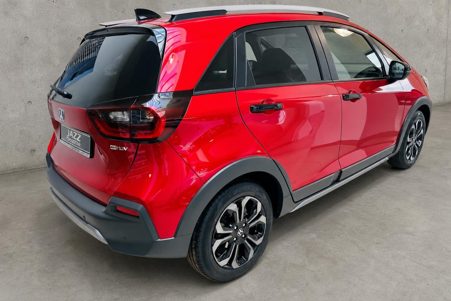 Honda Jazz Crosstar in Rot, Heckansicht schraeg mit schwarzen Applikationen