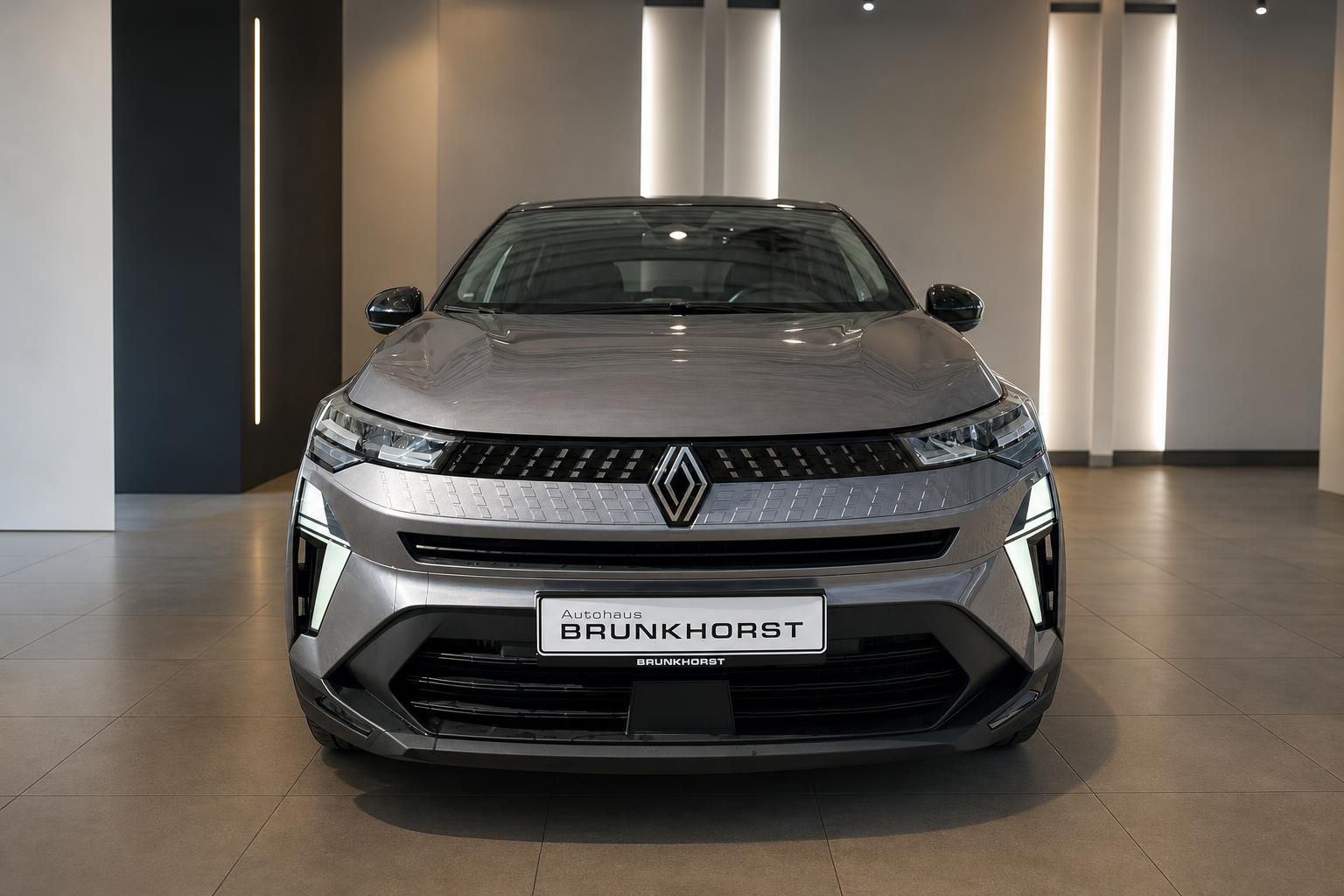 Renault Captur grau metallic Frontansicht mit markanter LED-Tagfahrlicht-Signatur im Showroom