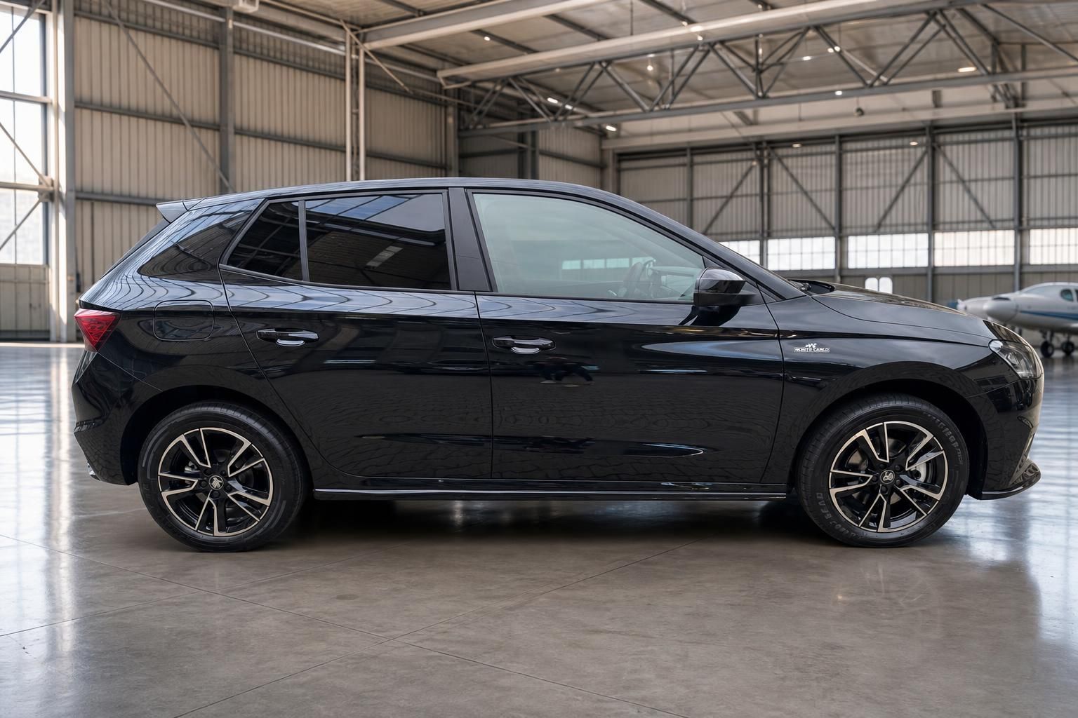 Schwarzer Skoda Fabia rechte Fahrzeugseite mit modernen Felgen in Fahrzeughalle