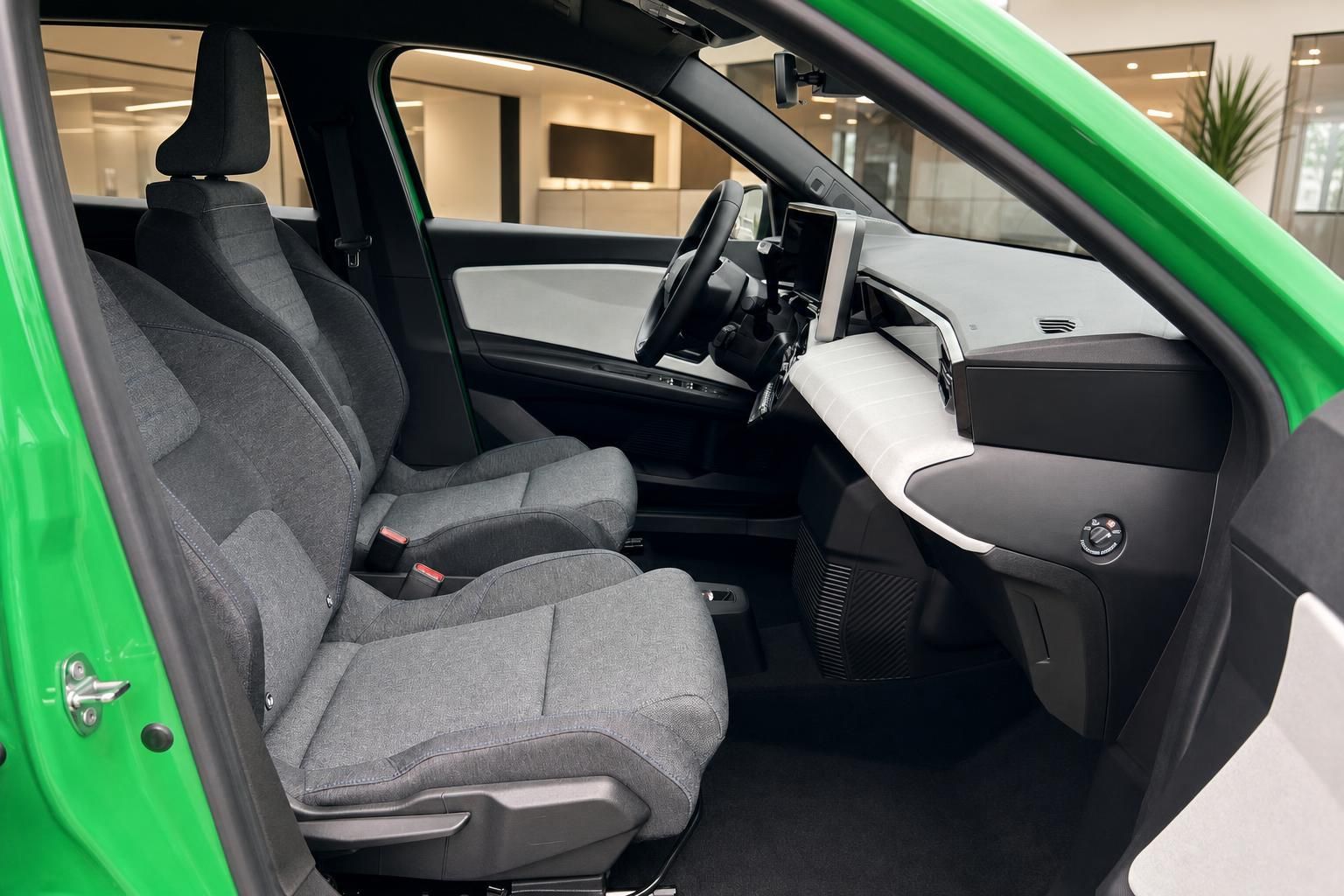 Innenraum grünes Auto mit grauen Stoffsitzen und modernem Armaturenbrett