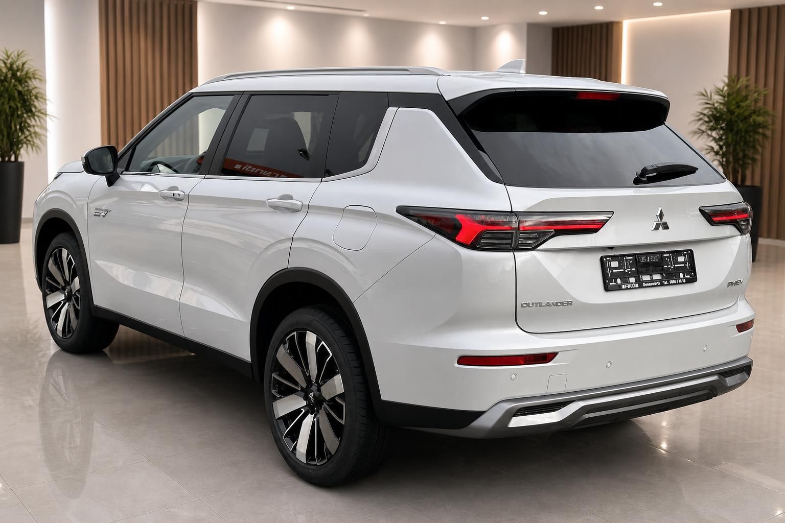 Mitsubishi Outlander PHEV weiss Heckansicht schraeg im Showroom mit LED-Rueckleuchten