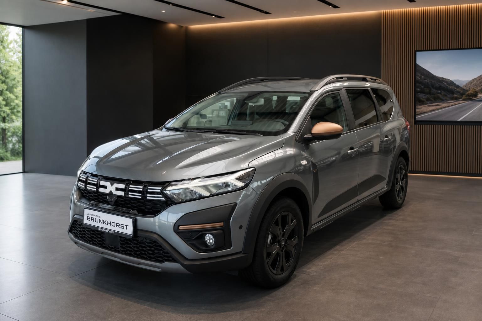 Dacia Jogger grau metallic Seitenansicht im modernen Autohaus Showroom