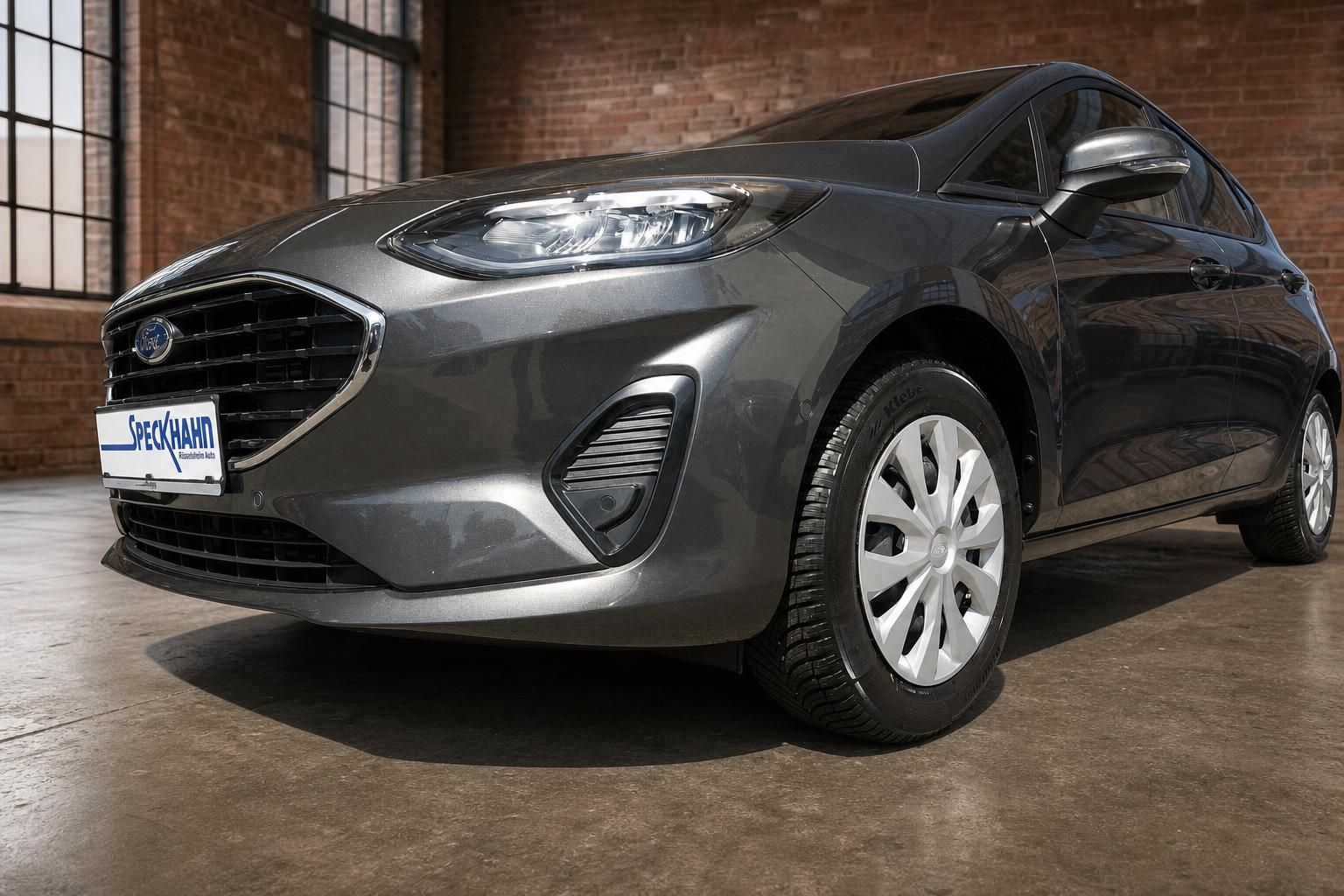 Ford Fiesta grau Schrägansicht vorne links – Frontschürze, LED-Scheinwerfer, Stahlfelgen, Speckhahn Kennzeichen