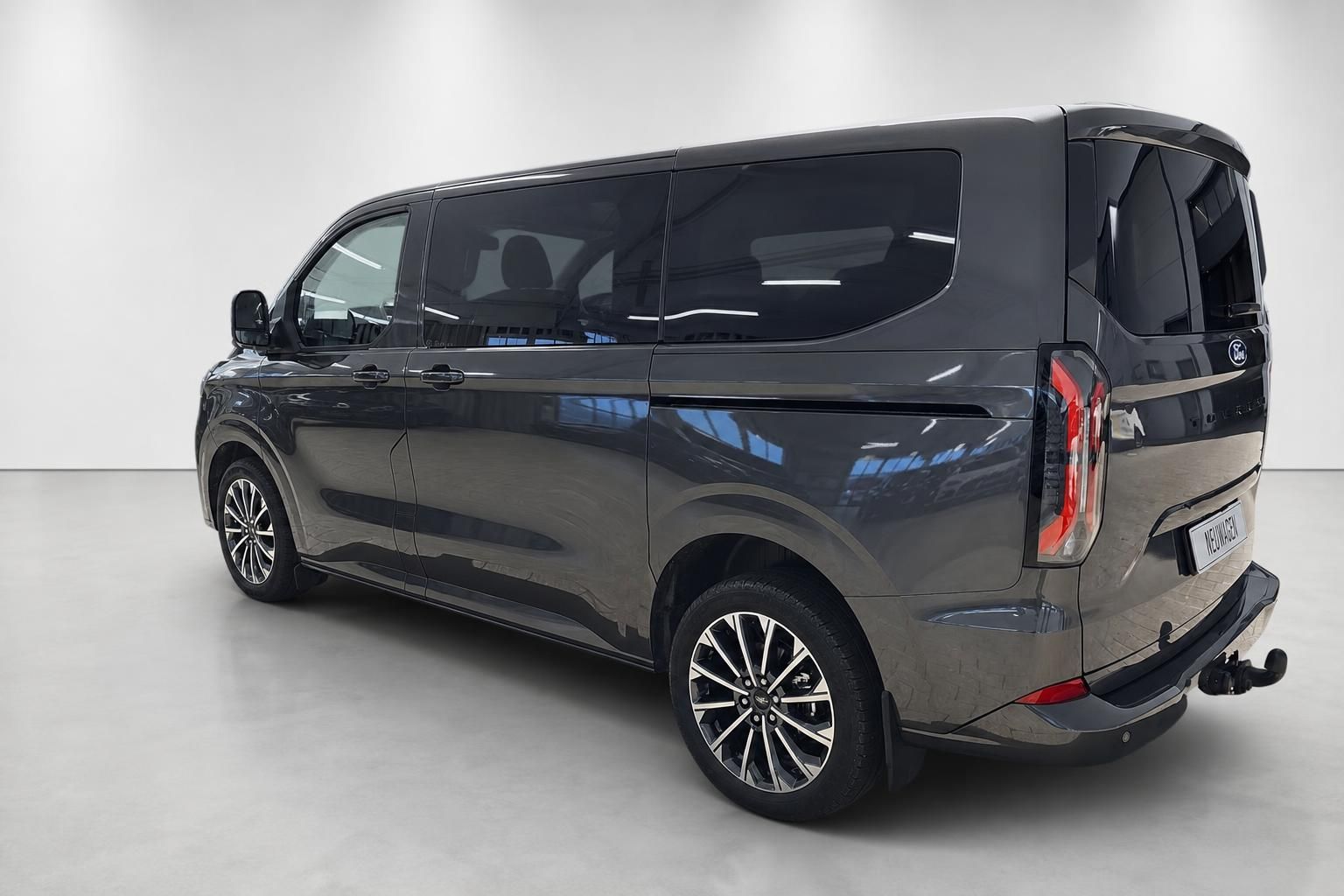 Ford Tourneo Custom in Grau-Metallic, Seitenansicht schräg von hinten