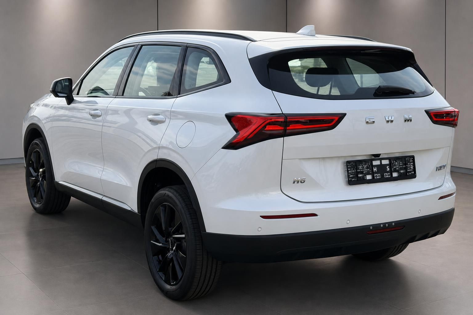 GWM Haval H6 HEV weißer SUV Hybrid Heckansicht schräg links im Autohaus