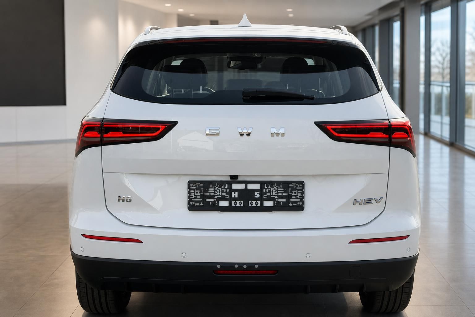 GWM Haval H6 HEV weißer SUV Hybrid direkte Heckansicht im Showroom