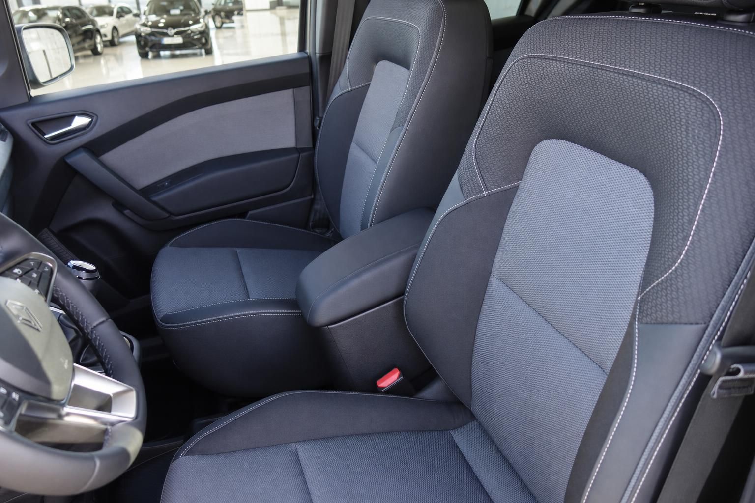 Komplette Ansicht der vorderen Fahrzeugsitze mit grauer Polsterung und Mittelkonsole