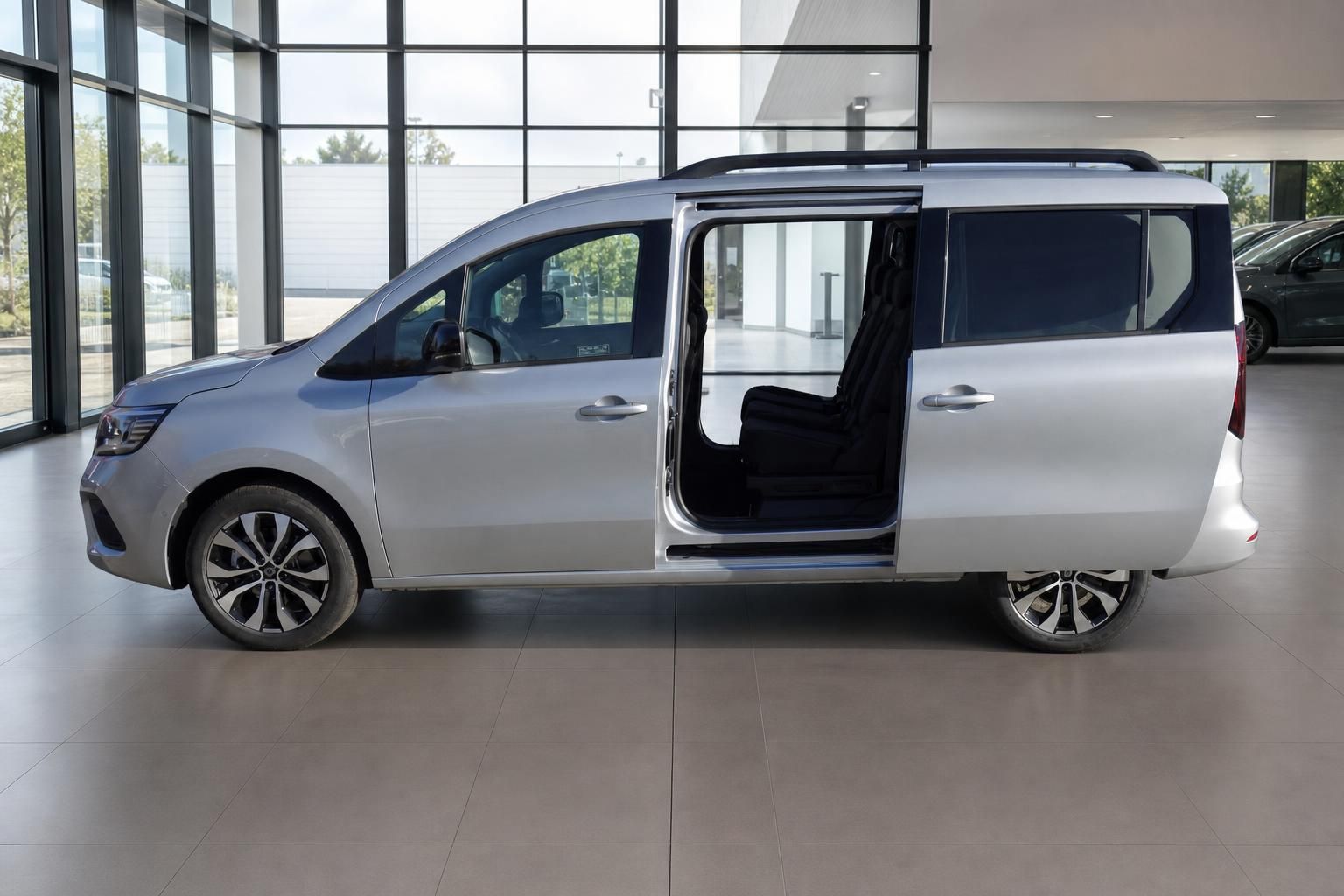 Silberner Minivan mit geöffneter Schiebetür im Autohaus Showroom