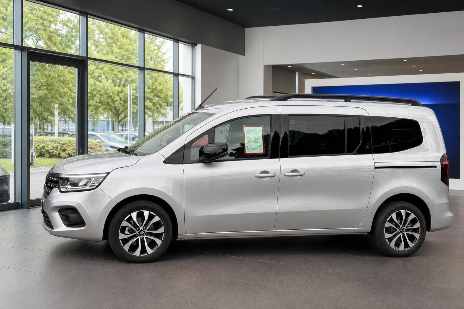 Renault Kangoo silber Seitenansicht links mit getönten Scheiben und modernem Profil im Showroom