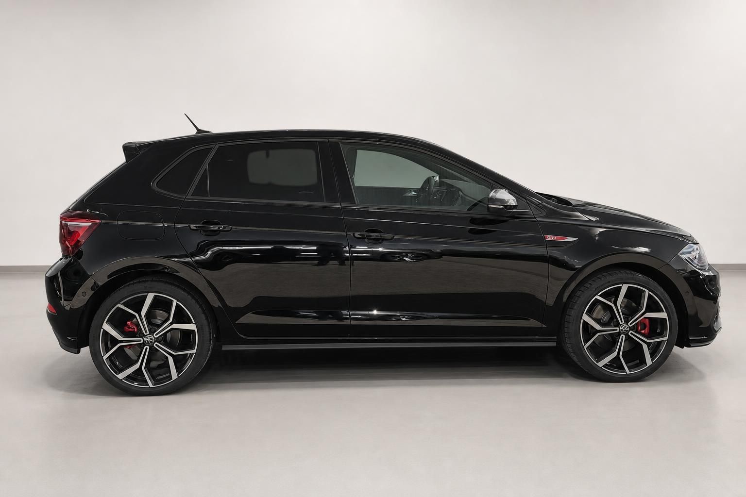 VW Polo GTI schwarz Seitenansicht mit Sportfelgen und roten Bremssaetteln