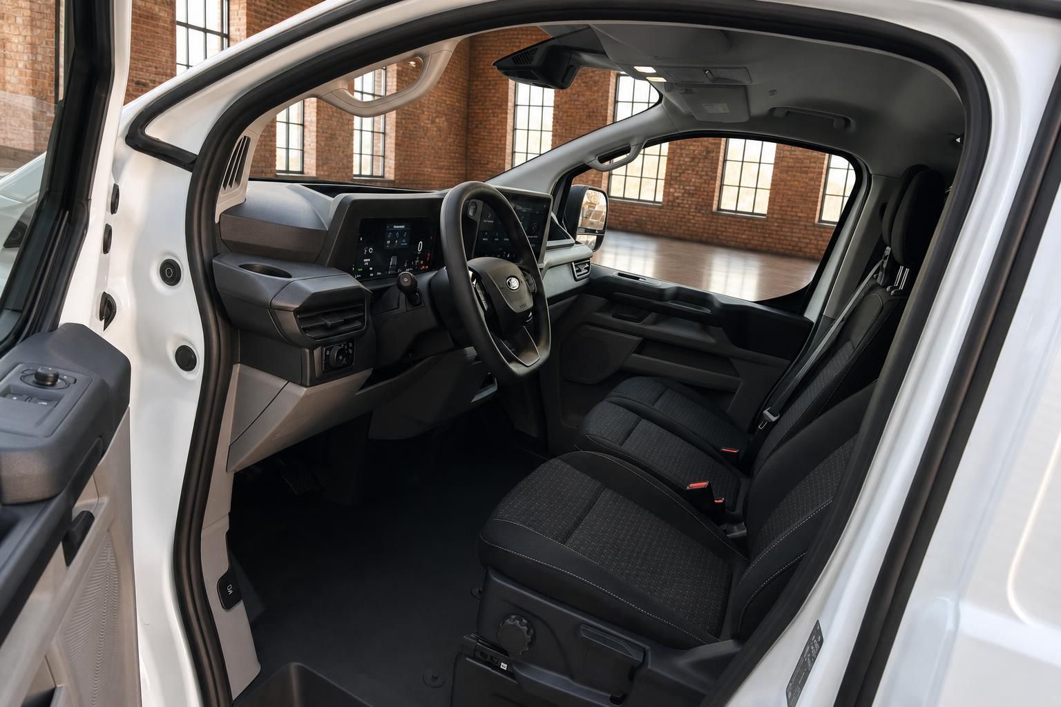 Ford Transit Custom Innenraum Fahrerseite mit Cockpit, Lenkrad und schwarzen Stoffsitzen