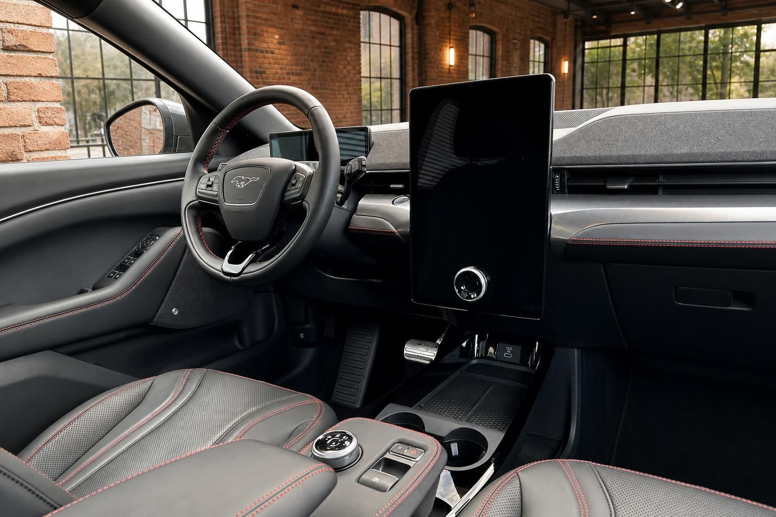 Ford Mustang Mach-E Cockpit – großer Touchscreen, Lenkrad mit Mustang-Logo, rote Ziernähte