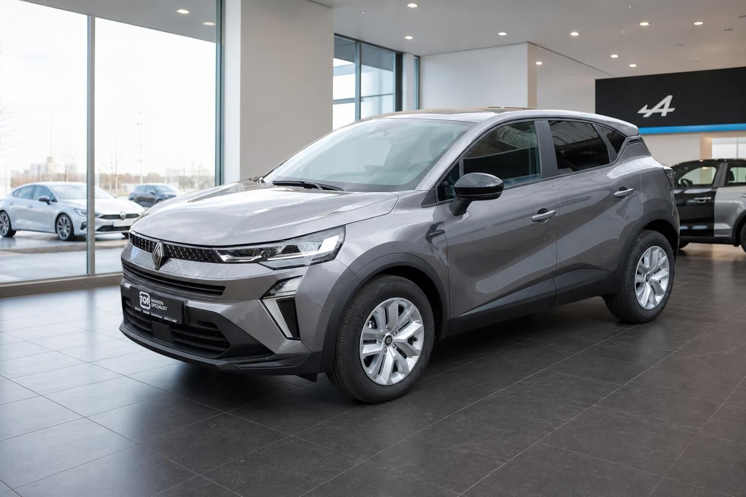 Renault SUV grau Schrägansicht vorne rechts mit Alpine Logo im Hintergrund