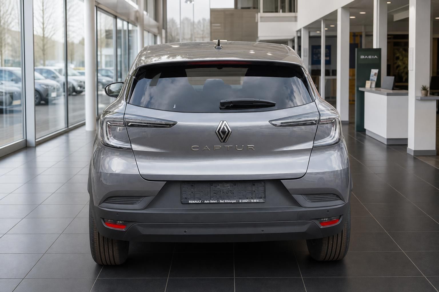 Renault Captur grau metallic Heckansicht mit Kennzeichen im Autohaus Showroom