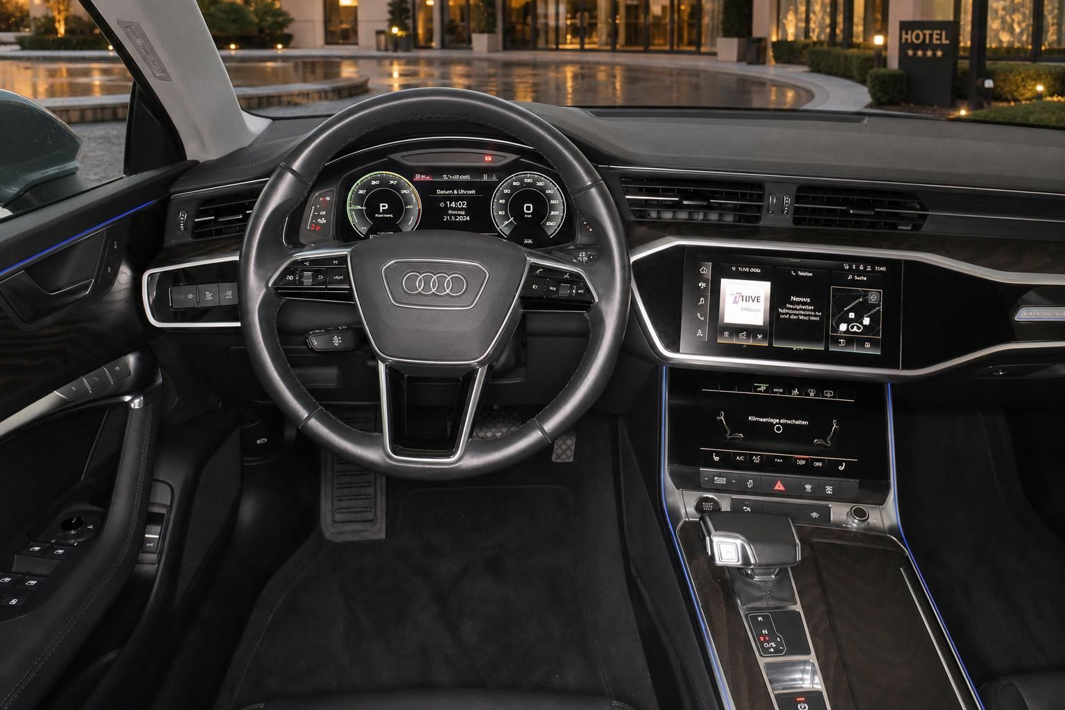 Audi A7 Cockpit mit Lenkrad und Multimedia-Bildschirm vor Hoteleingang