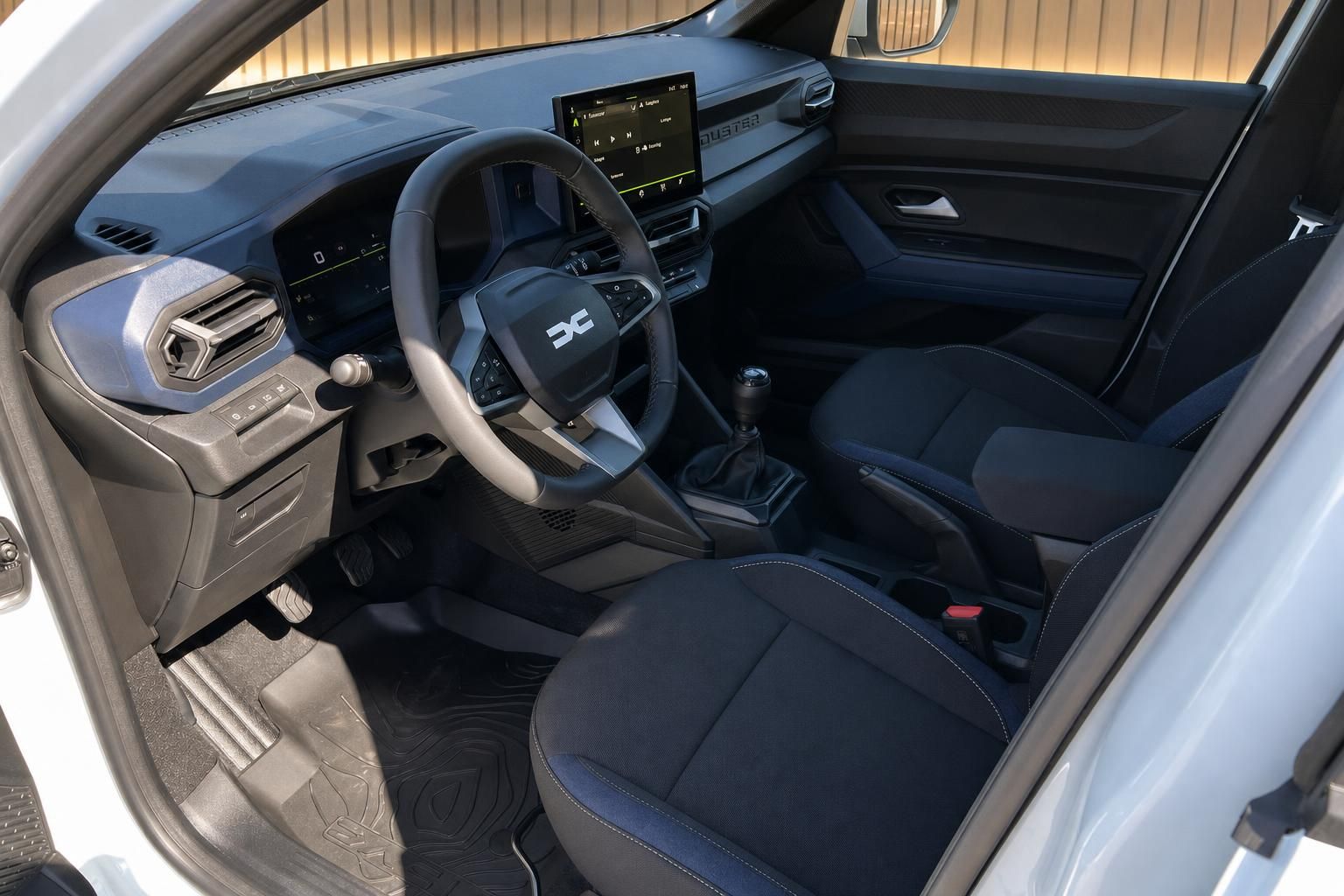 Dacia Duster Innenraum mit Lenkrad, Touchscreen-Display und manueller Schaltung in schwarz