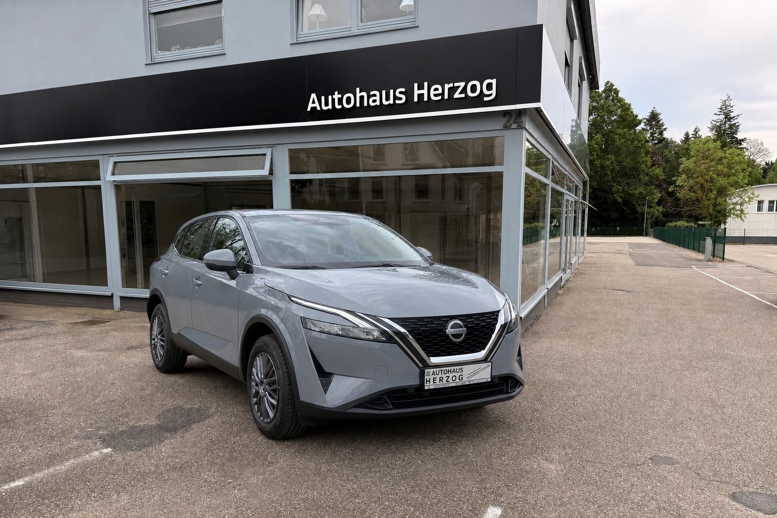 Nissan SUV grau metallic Schrägansicht von vorne im Autohaus-Showroom mit modernem Design