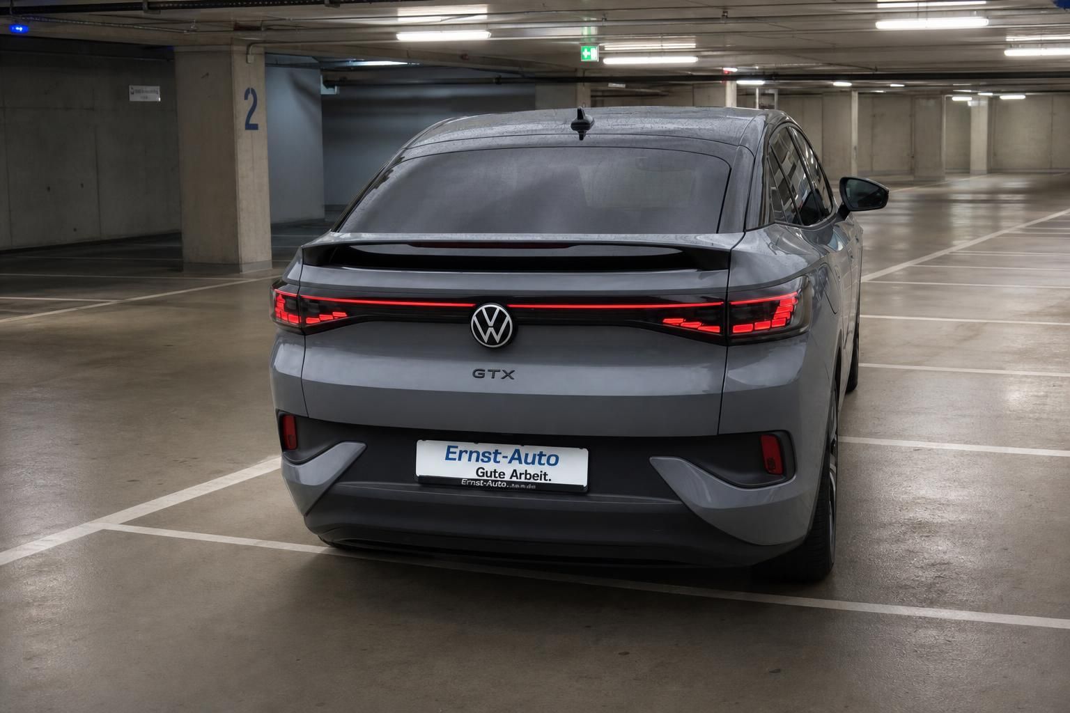 VW ID.4 GTX grau, Heckansicht mit LED-Rueckleuchten im Parkhaus