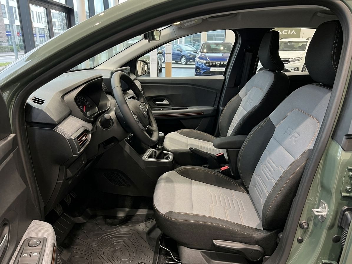 Dacia Fahrzeuginnenraum Fahrersitz mit grau-weißer Polsterung und Mittelkonsole