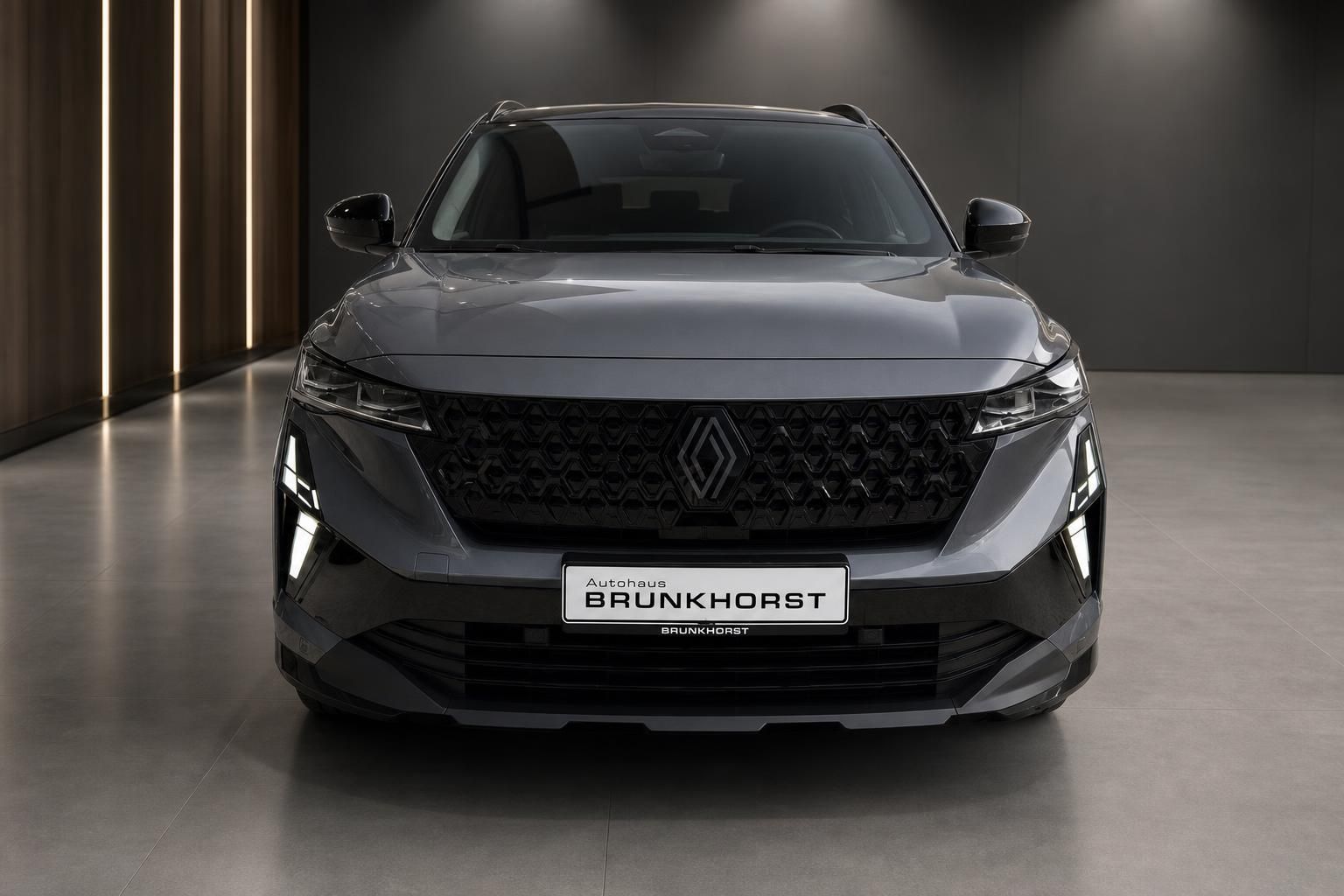 Renault Austral in Grau, Frontansicht mit Kühlergrill im Showroom