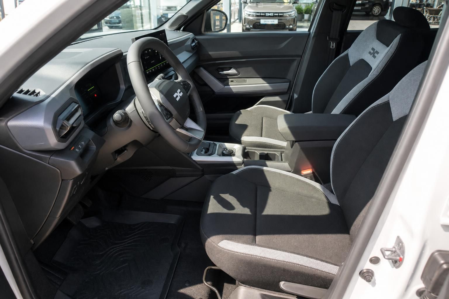 Modernes Fahrzeug-Cockpit mit Lenkrad, Armaturenbrett und komfortablen Sitzen in Grau-Schwarz