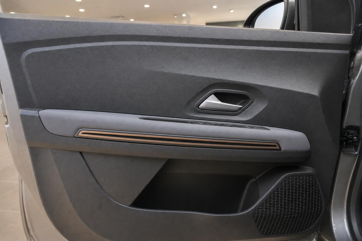 Auto-Türverkleidung innen mit grauem Kunststoff, Griff und Lautsprecher-Detail