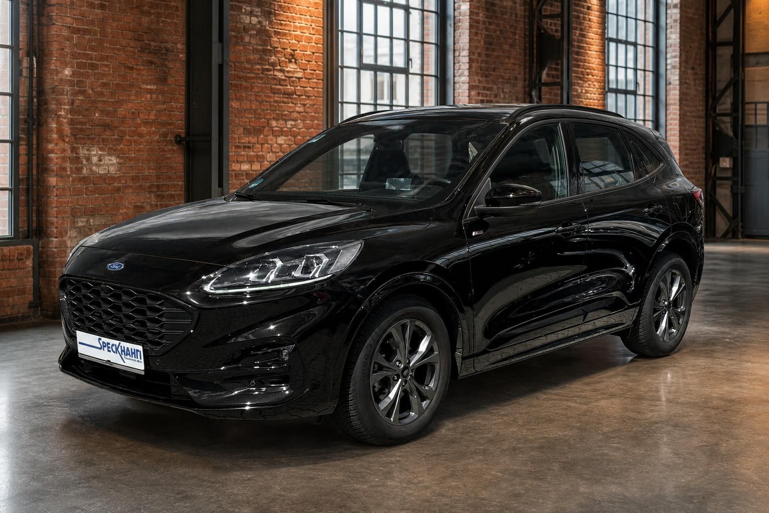 Ford Kuga schwarz Frontansicht in Industriehalle mit Backsteinmauer