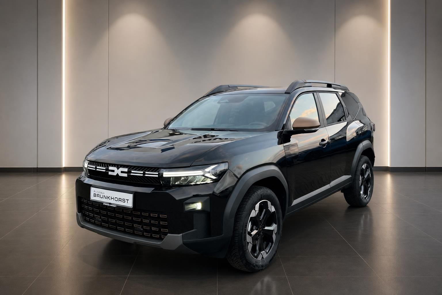 Dacia Bigster SUV Schrägansicht von vorn in grau-schwarz mit Dachreling und Unterfahrschutz