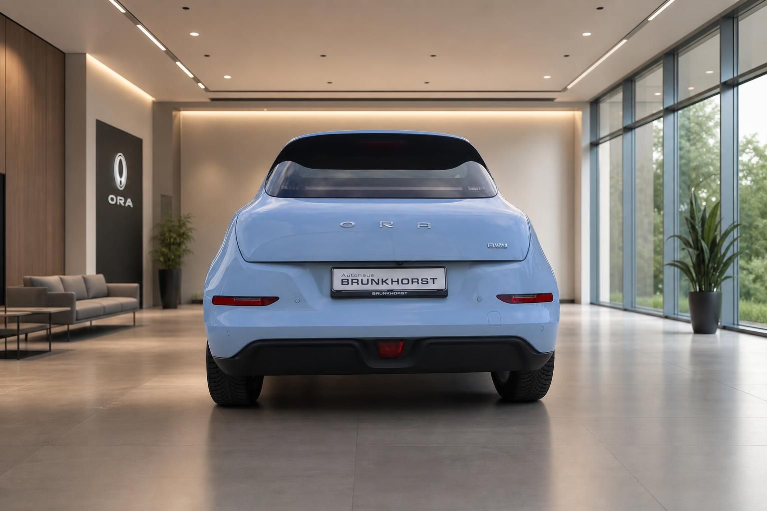 ORA Elektroauto hellblau, Heckansicht mit ORA-Schriftzug und Händlerkennzeichen im Autohaus