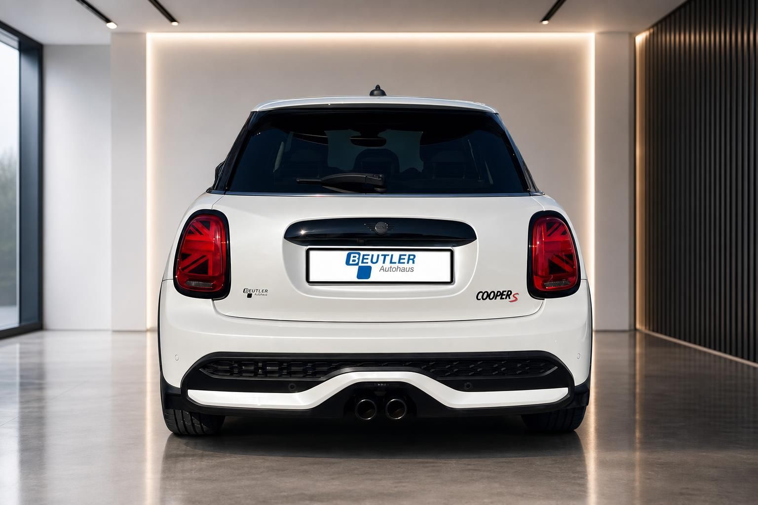 MINI Cooper S weiß, direkte Heckansicht mit Doppelendrohr im Showroom