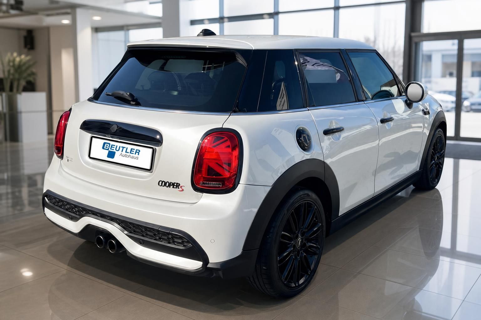 Weißer MINI Cooper S schräg von hinten, schwarze Alufelgen im Autohaus