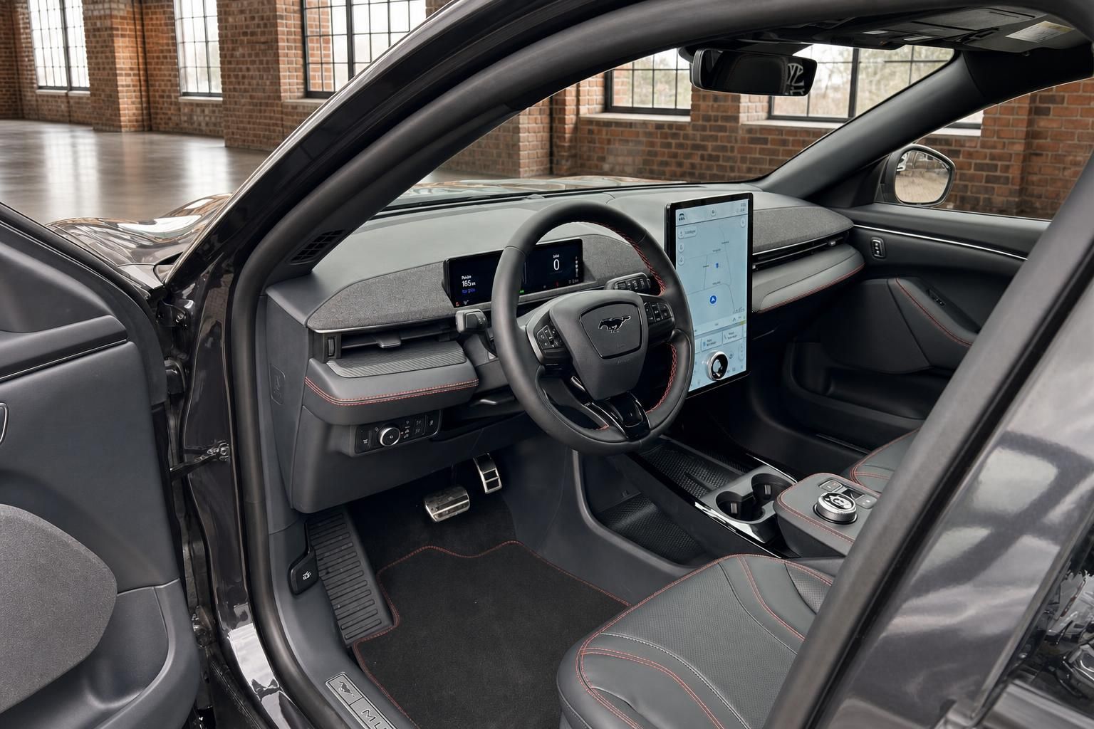 Ford Mustang Mach-E Innenraum Cockpit mit großem Touchscreen Lenkrad und roten Ziernähten