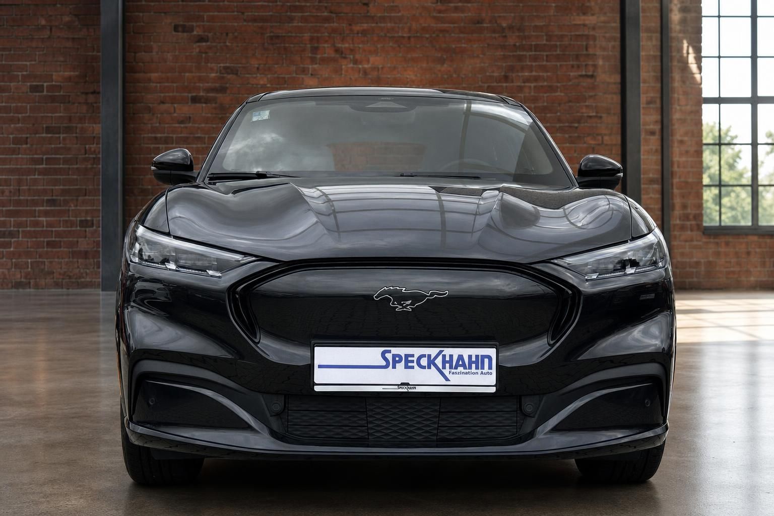 Ford Mustang Mach-E schwarz Frontansicht mit Speckhahn Kennzeichenrahmen in Industriehalle