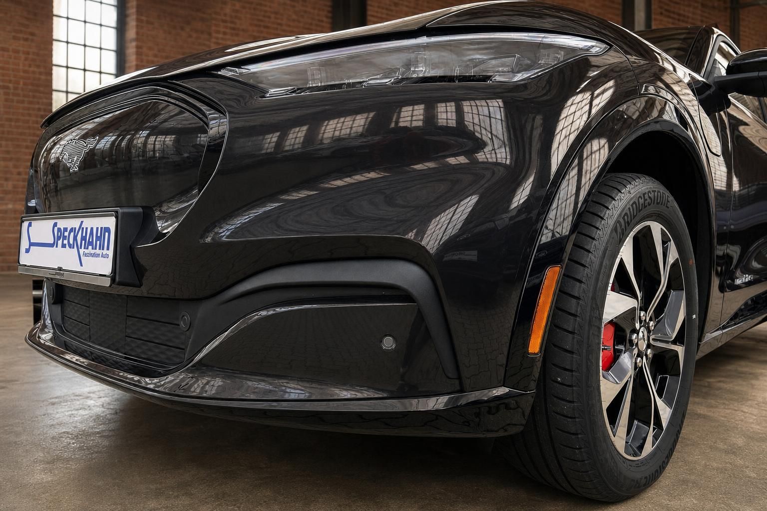 Ford Mustang Mach-E schwarz Frontpartie Nahaufnahme mit Kennzeichenhalter Speckhahn